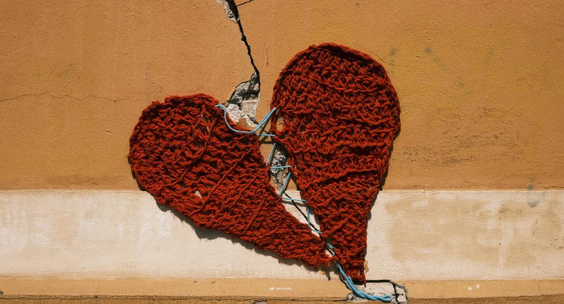 Coeur tricoté contre un mur craqué 