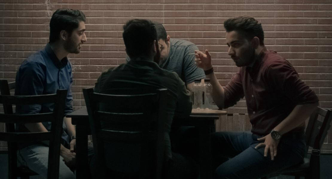 Quatre hommes assis à une table
