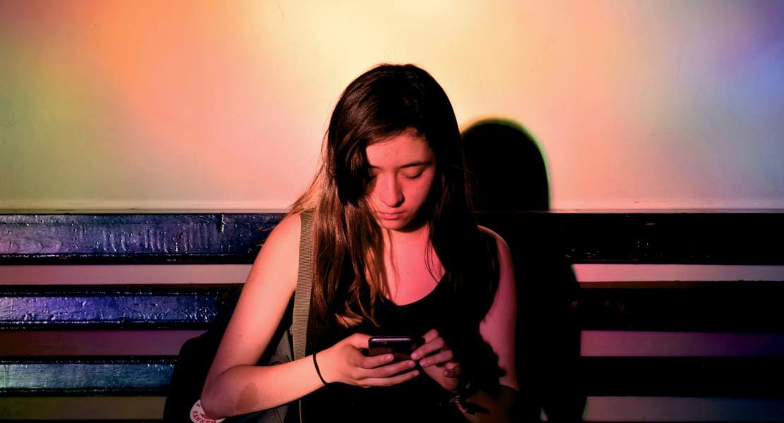 Young woman looking at her phone on a bench