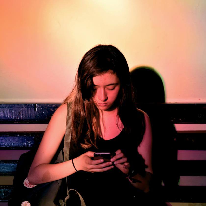 Young woman looking at her phone on a bench