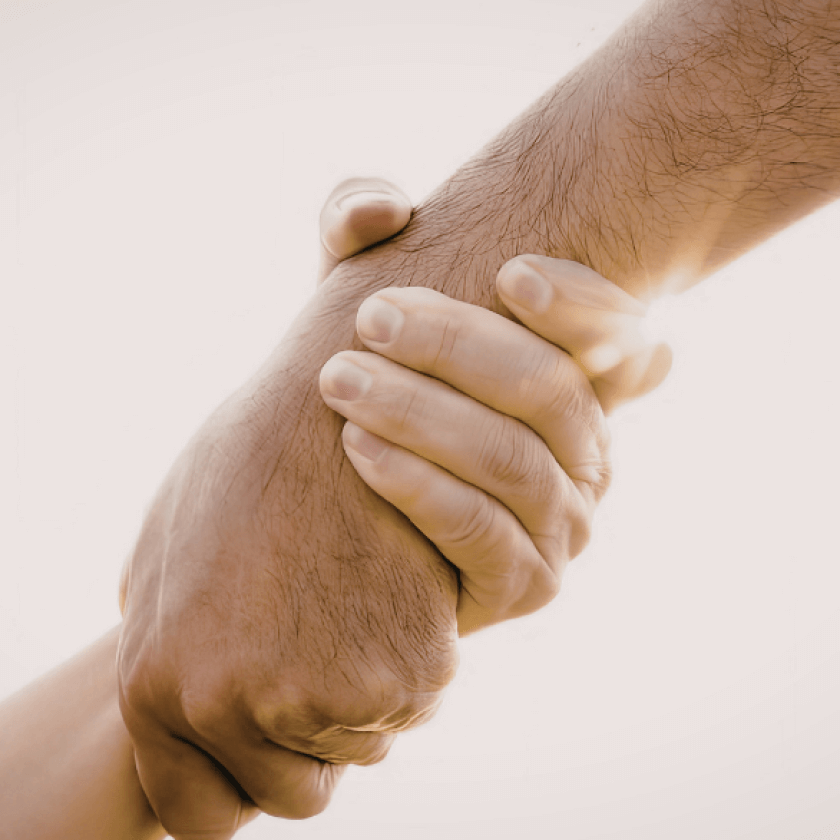 Hand reaching out to another who holds it firmly