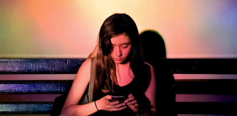 Young woman looking at her phone on a bench