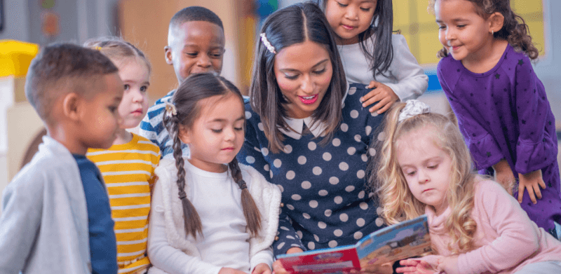 Early childhood educator surrounded by children from multiples origins
