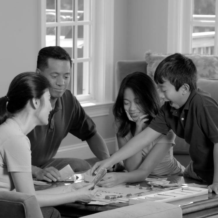 Two adults and children playing a board game
