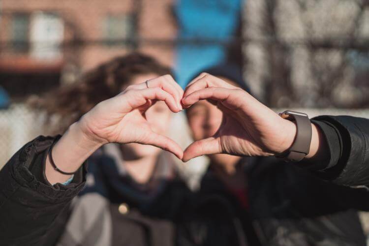 young couple forming a heart with their hands